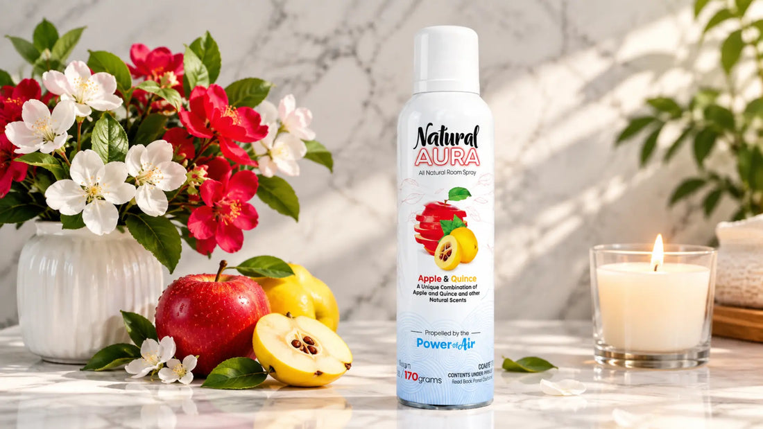 Apple & Quince natural room spray air freshener on marble surface with flowers, fruit, and candle.